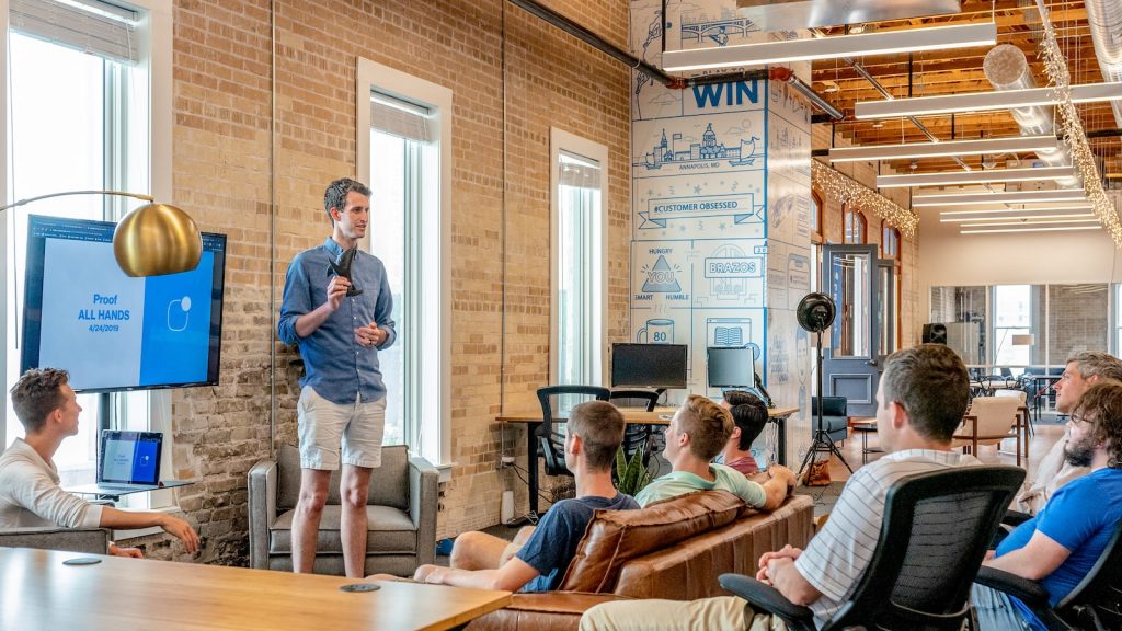 man standing in front of group of men in a purpose company